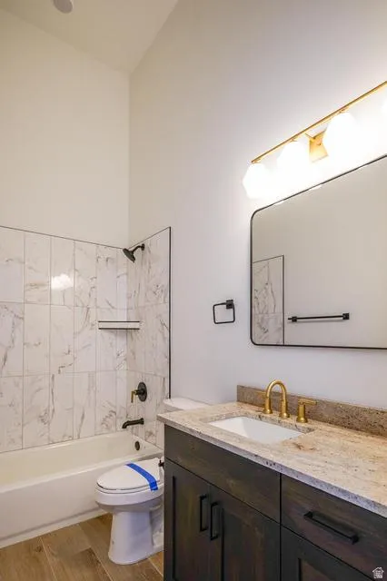 Bathroom featuring a tub/shower combination with marble-look tile surround and a built-in niche