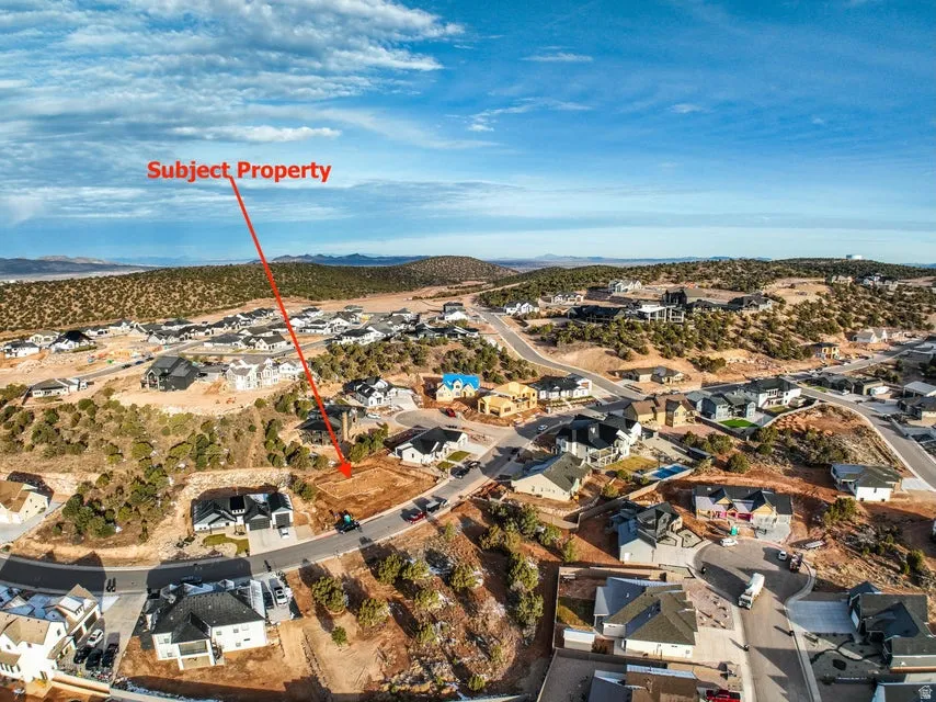 Aerial view of property and surrounding area featuring nearby suburban area