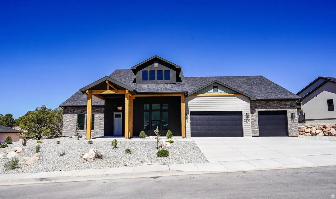 Modern exterior featuring a stone and siding facade with dark trim accents
