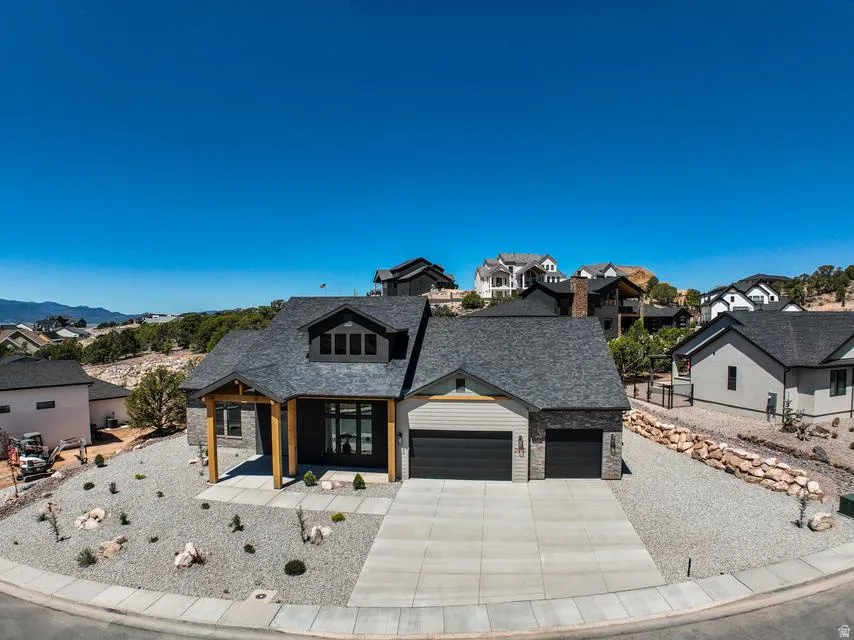 Contemporary residence featuring a dark gray shingle roof and a two-car garage