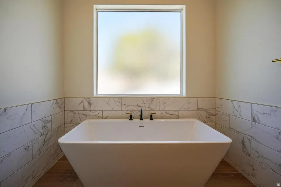 Freestanding soaking tub with a matte black and brass faucet