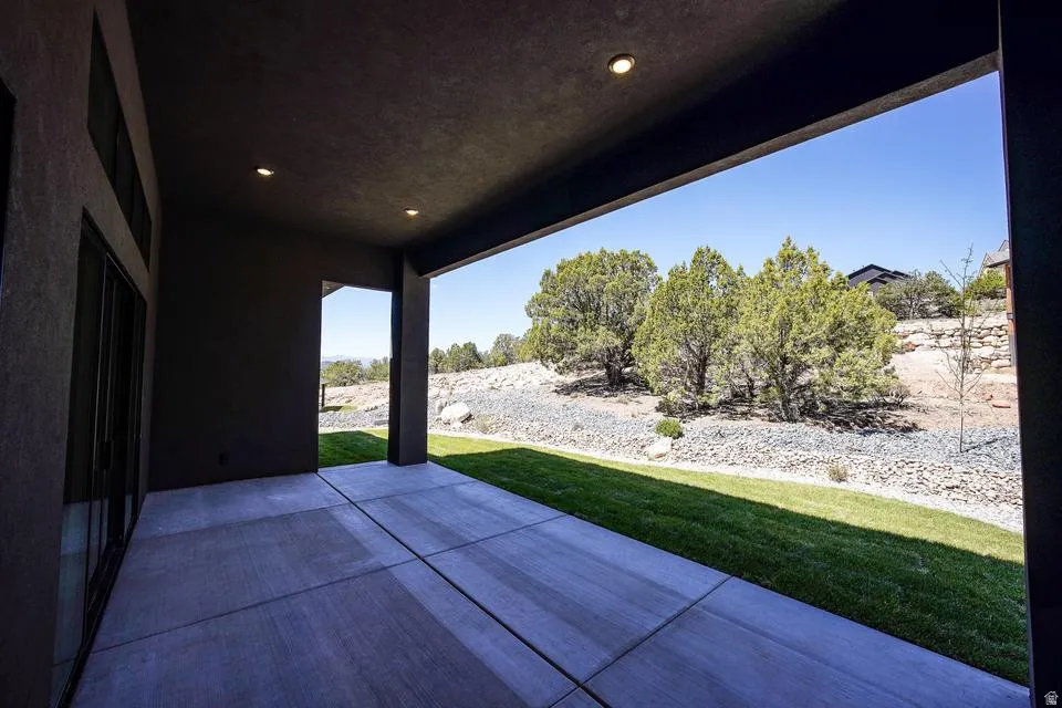 Covered patio with recessed lighting, concrete flooring, and a sliding glass door