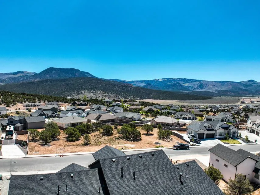 Expansive neighborhood with a mountainous backdrop, featuring varied home designs and mature landscaping