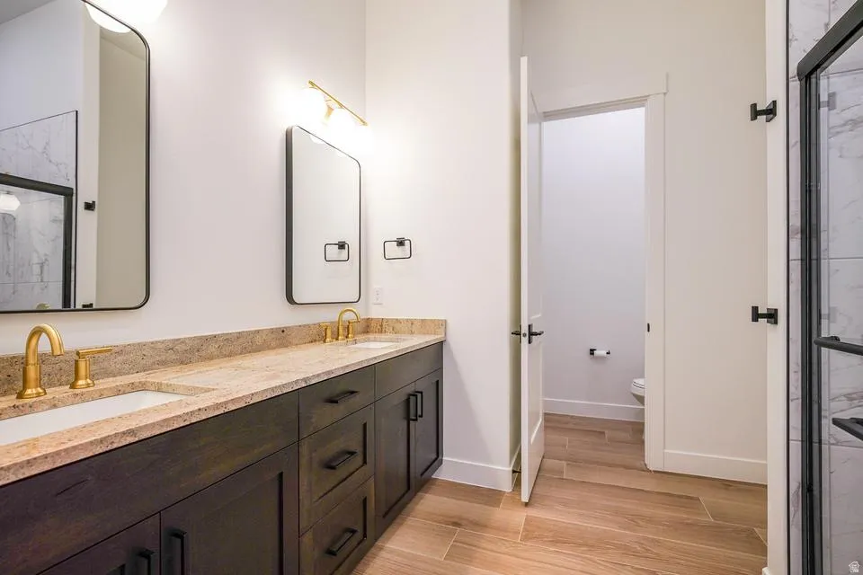 Dual vanity with gold-finish faucets and hardware, set against a light-toned countertop