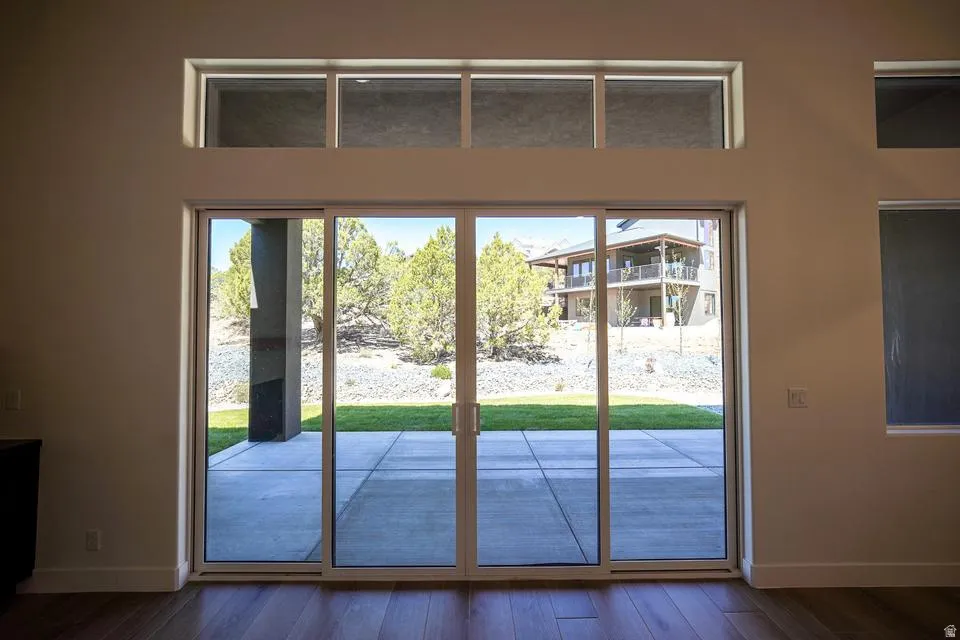 Sliding glass doors opening to a concrete patio and green lawn