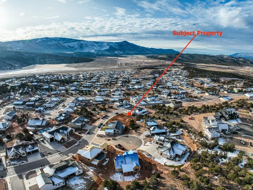 Aerial view of property's location with nearby suburban area and mountains