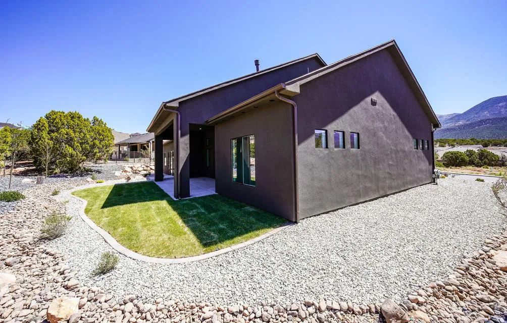 Modern exterior featuring dark stucco siding and a gabled roofline