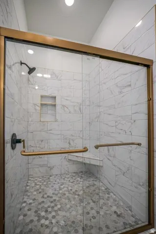 Glass-enclosed shower with bronze-finish framing