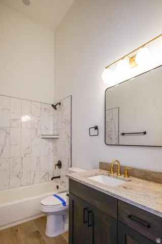 Bathroom featuring a tub/shower combination with marble-look tile surround and a built-in niche