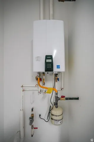 Wall-mounted tankless water heater with visible plumbing and expansion tank
