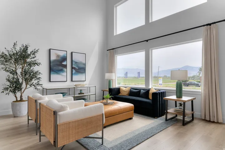 Living area featuring a towering ceiling, light wood-style flooring, and a mountain view