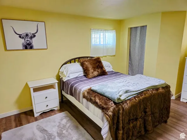 Bedroom with wood finished floors and baseboards