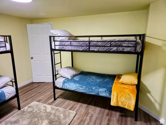 Bedroom with wood finished floors and baseboards
