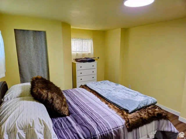 Bedroom featuring baseboards and wood finished floors