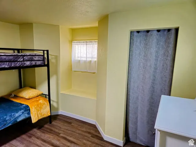 Bedroom with dark wood-type flooring and a textured ceiling