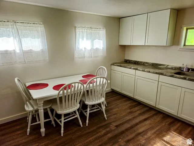 Dining space featuring dark wood finished floors and baseboards