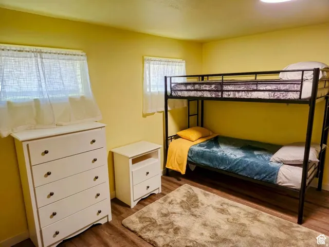 Bedroom with dark wood-style floors and baseboards