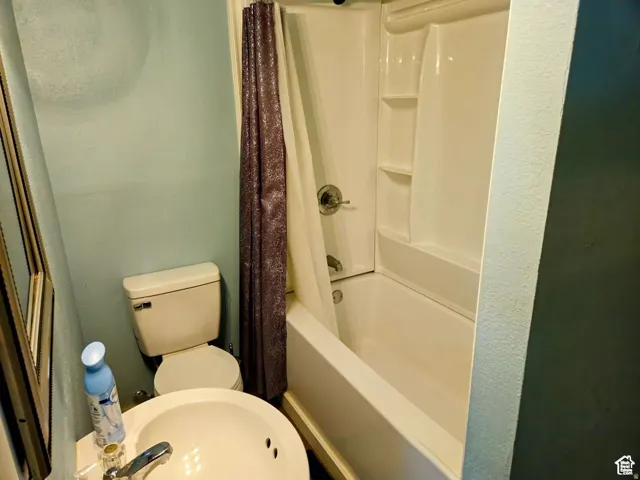 Bathroom featuring shower / tub combo with curtain and a sink