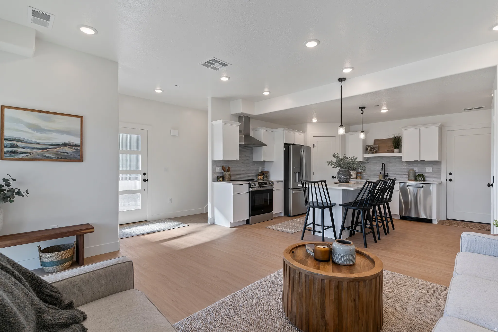 Living room with light wood-type flooring and recessed lighting