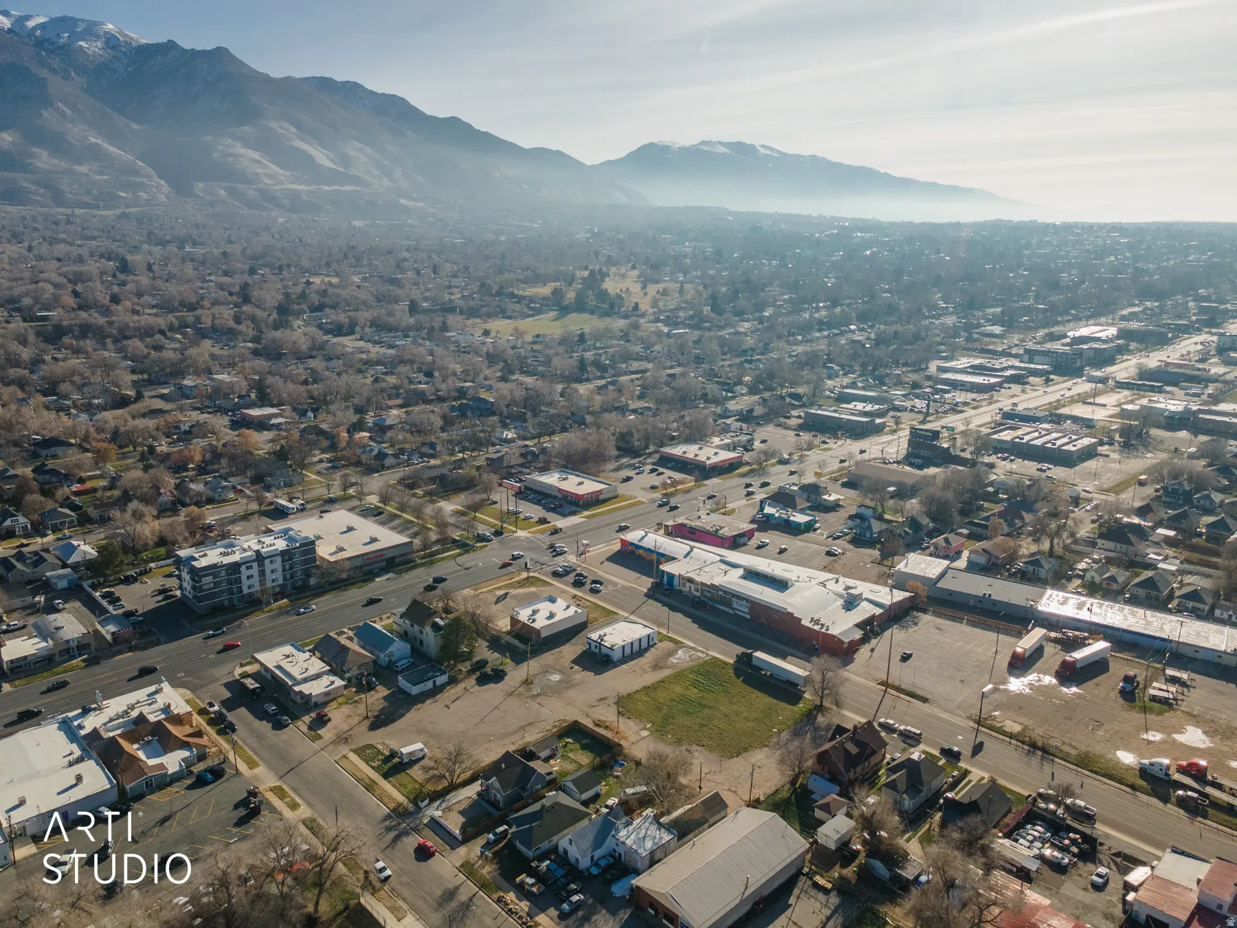 Aerial view of property and surrounding area with a mountain backdrop and industrial structures