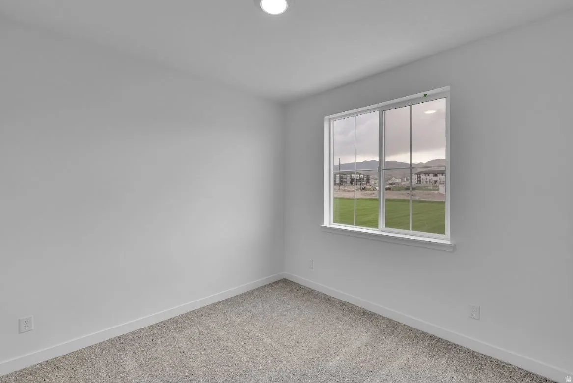 Spare room with light colored carpet, recessed lighting, and a mountain view