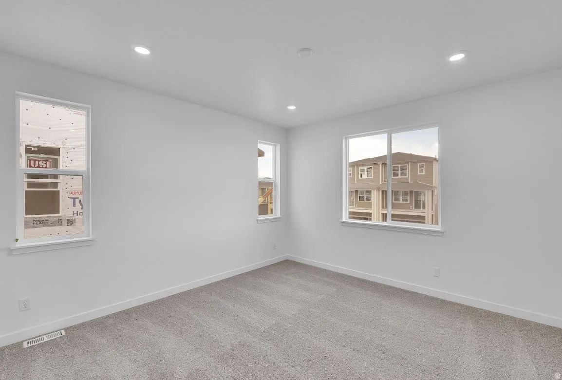 Carpeted empty room with baseboards and recessed lighting