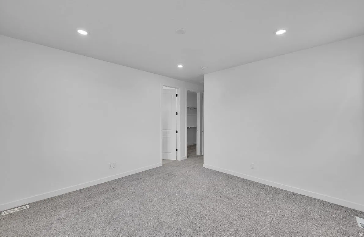 Unfurnished room with light carpet and recessed lighting