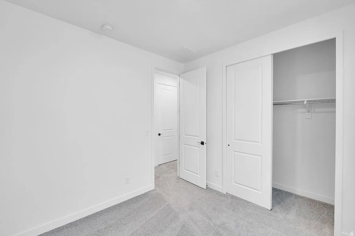 Unfurnished bedroom featuring carpet flooring and a closet