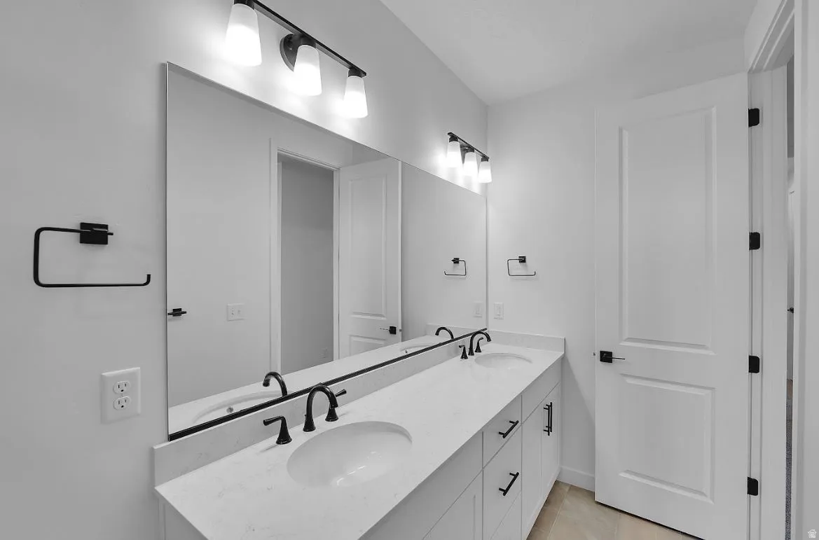 Full bathroom featuring double vanity and light tile patterned floors