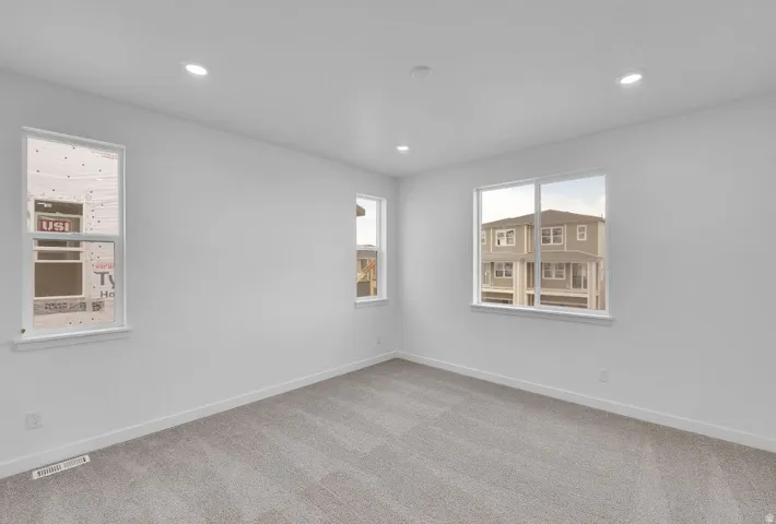Carpeted empty room with baseboards and recessed lighting