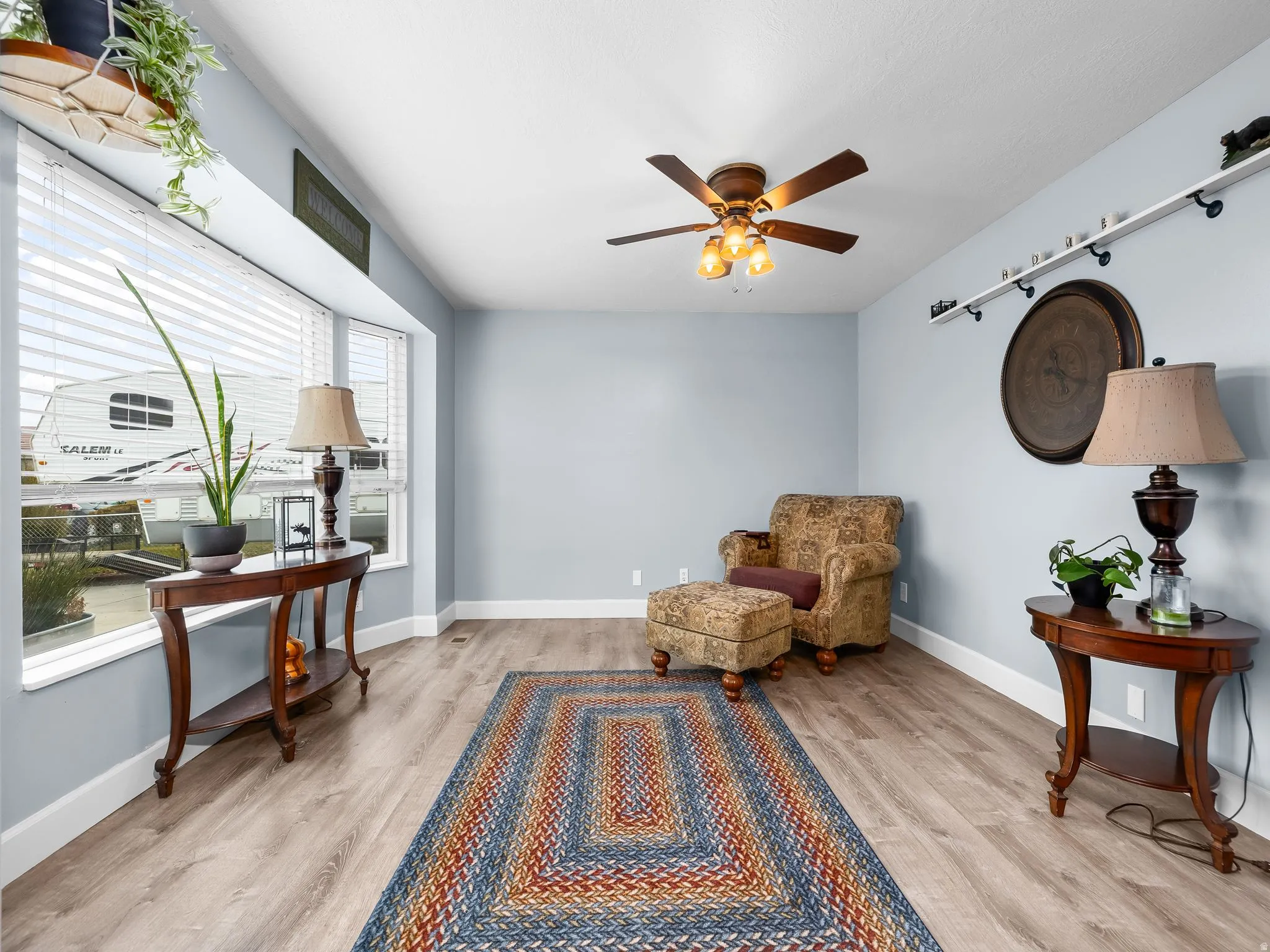 Living area featuring light wood-type flooring and a ceiling fan
