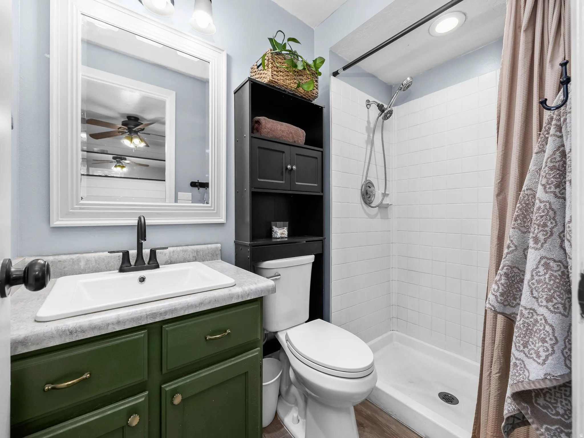 Full bathroom featuring vanity, a stall shower, and ceiling fan