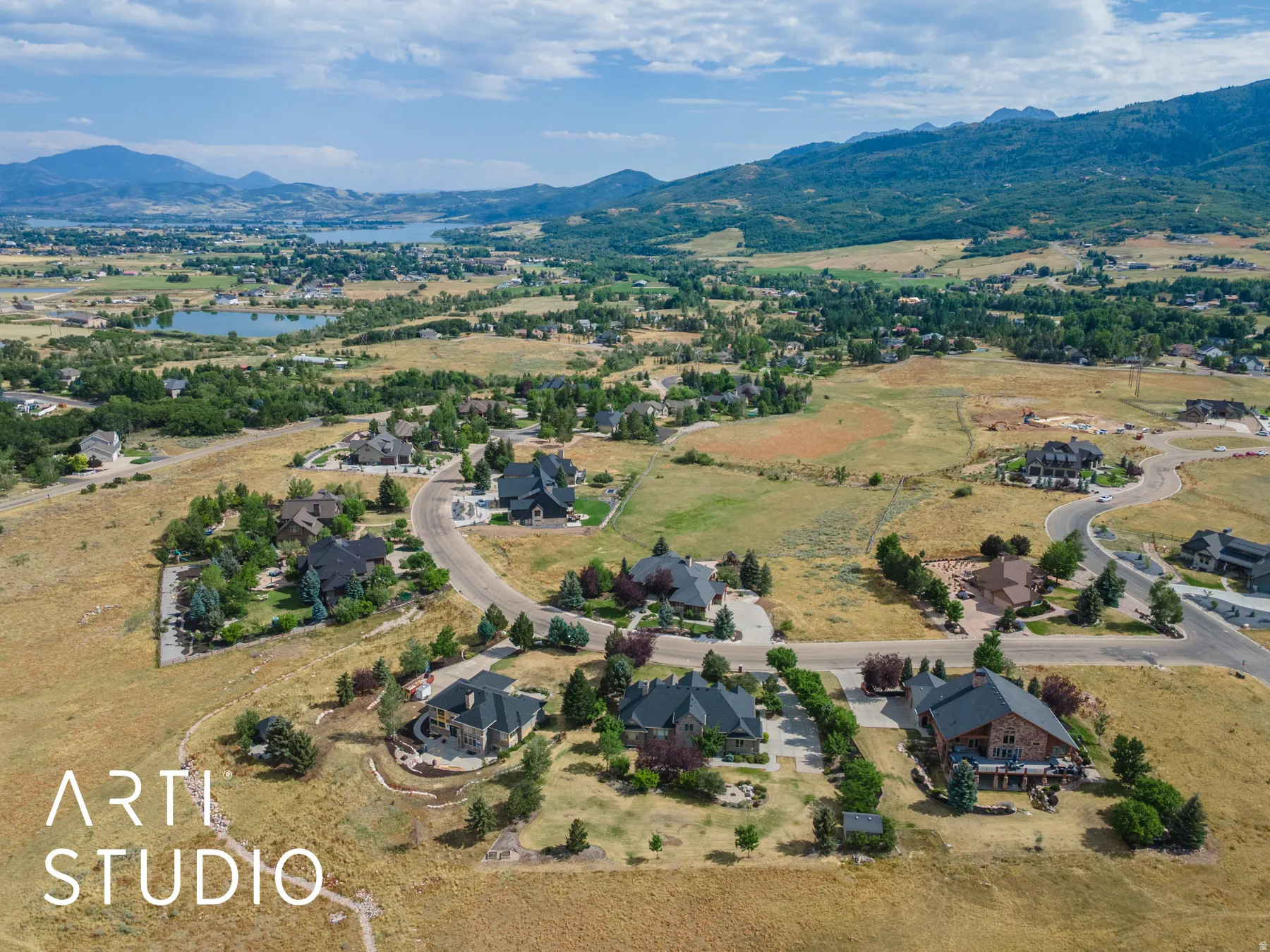 Aerial view of property's location featuring a water and mountain view and nearby suburban area