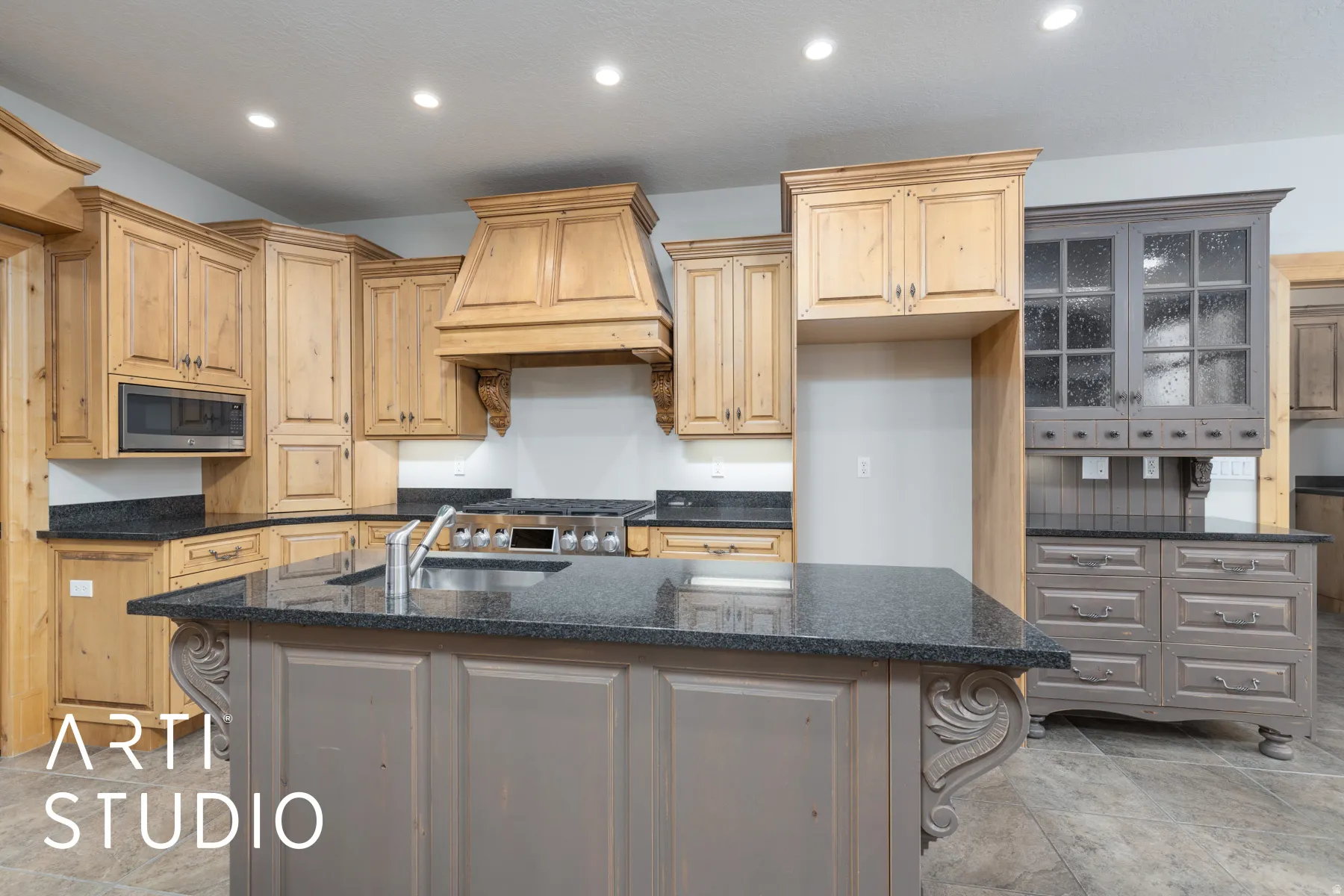 Kitchen with recessed lighting, dark stone countertops, custom exhaust hood, an island with sink, and glass insert cabinets