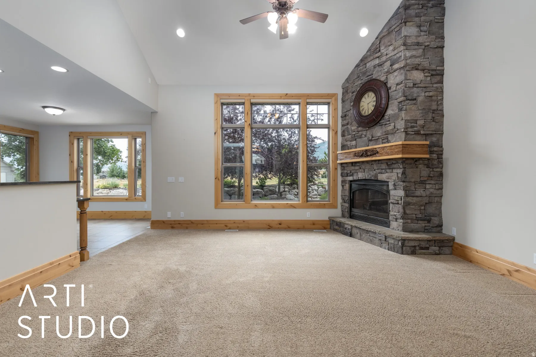 Unfurnished living room with a stone fireplace, healthy amount of natural light, ceiling fan, carpet, and recessed lighting