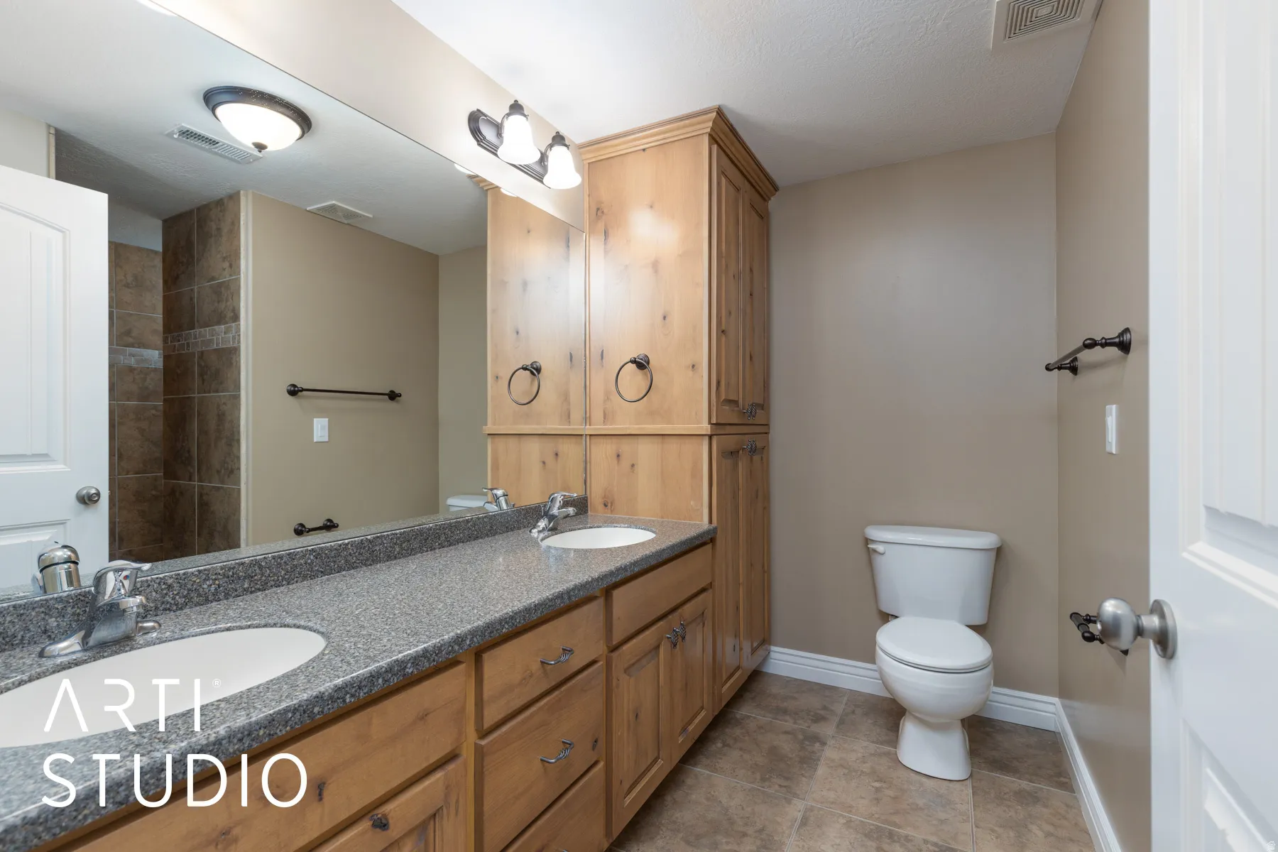 Full bathroom with double vanity, light tile patterned floors, and a shower