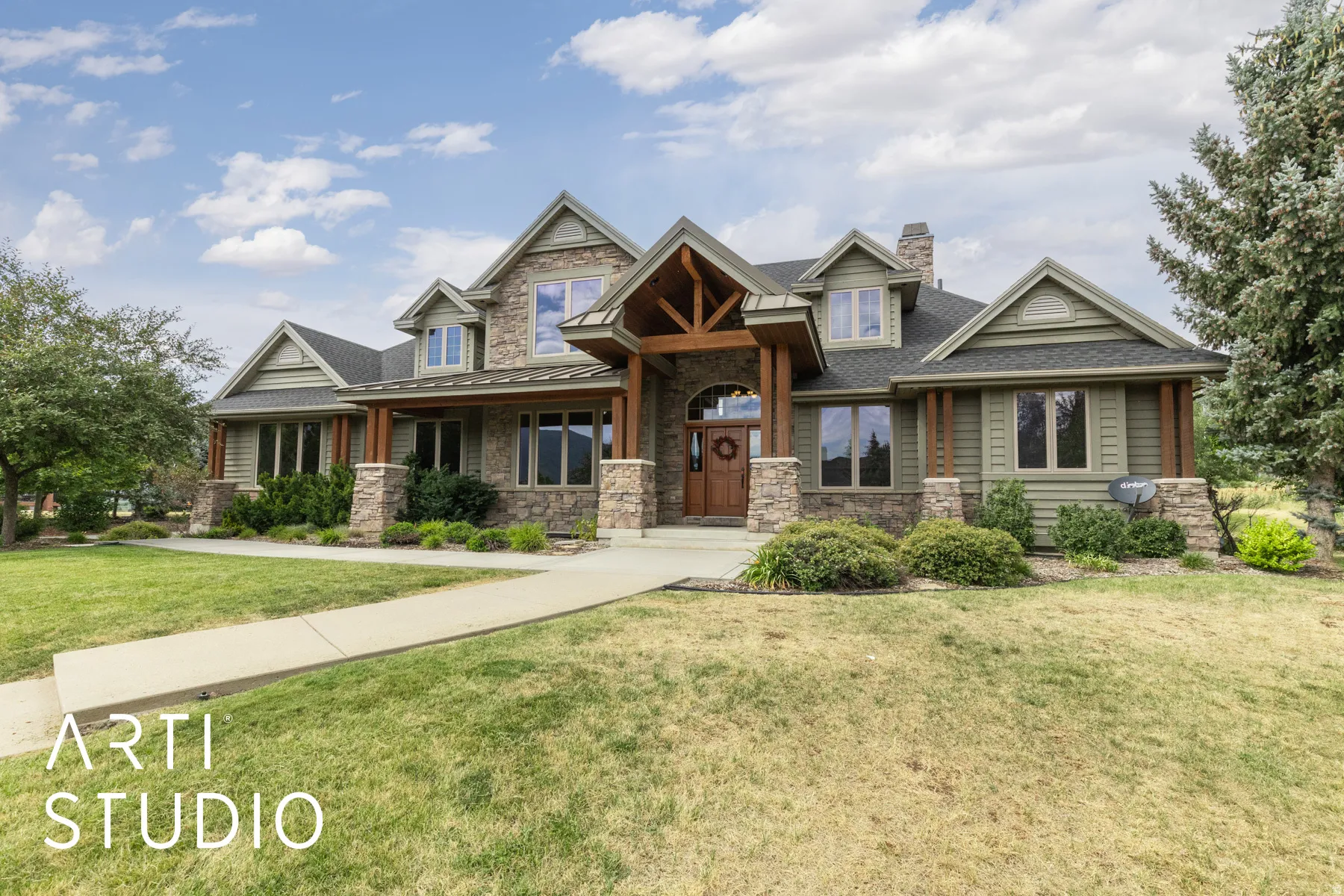 Craftsman-style home featuring covered porch, a front lawn, stone siding, and a chimney