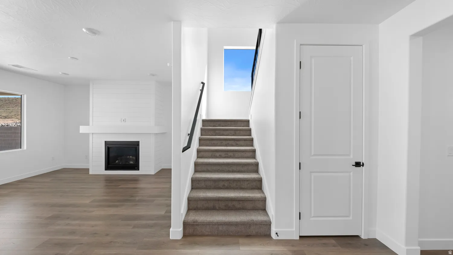 Stairway featuring a large fireplace and wood finished floors