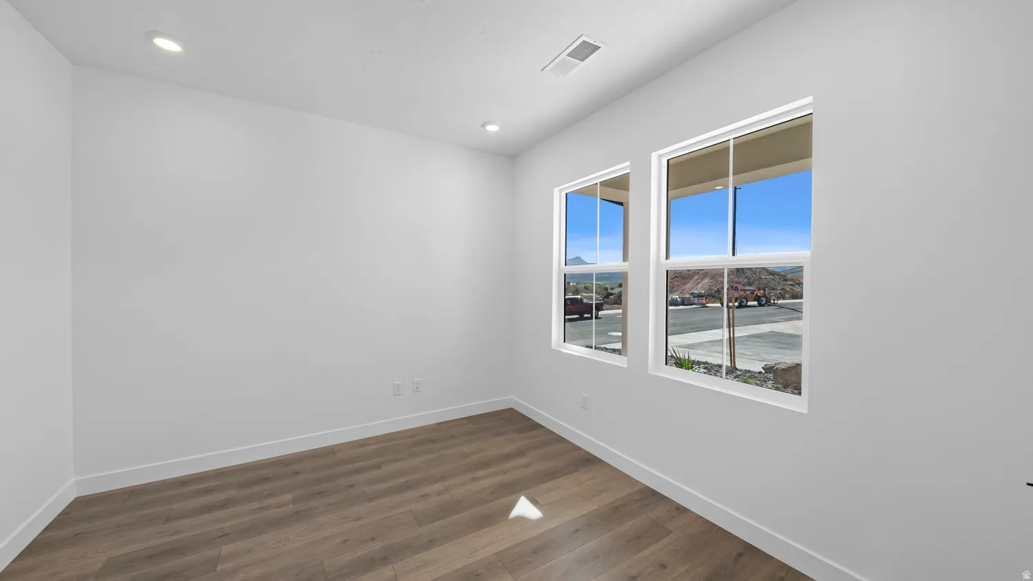 Unfurnished room with dark wood finished floors and recessed lighting