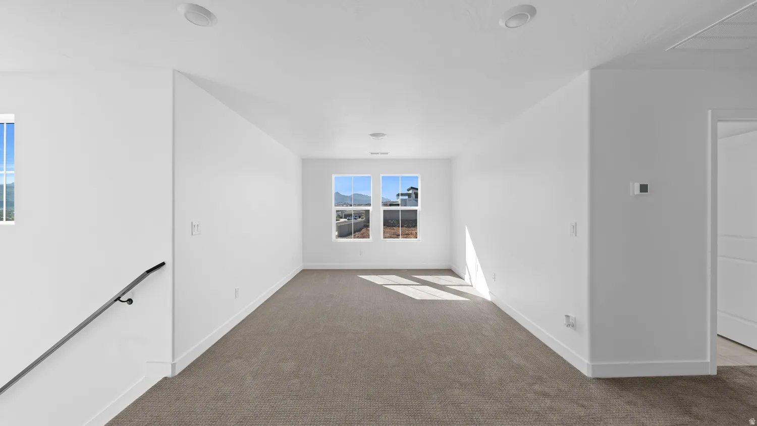 Unfurnished room with dark carpet and a mountain view
