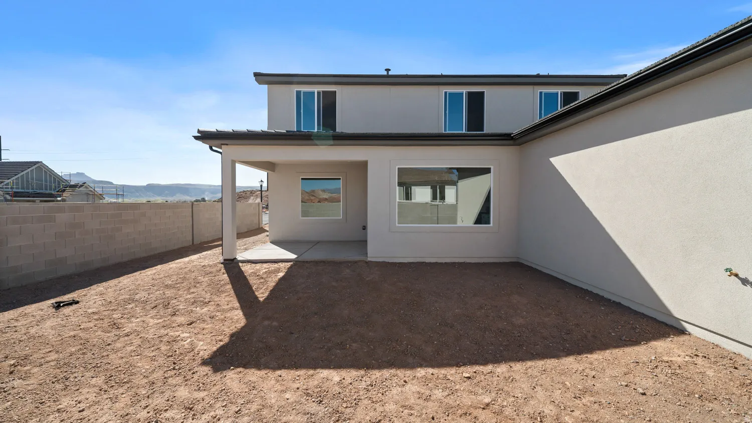 Back of house featuring a patio, a mountain view, and stucco siding