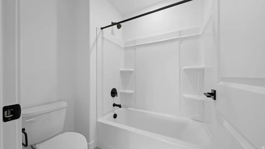 Full bathroom featuring toilet and bathing tub / shower combination