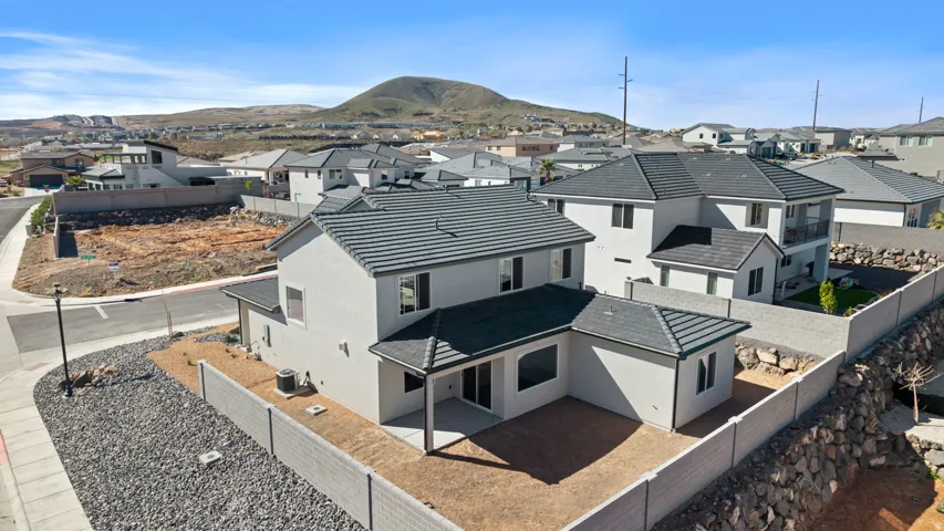 Back of property featuring a residential view, a fenced backyard, stucco siding, a patio area, and a mountain view