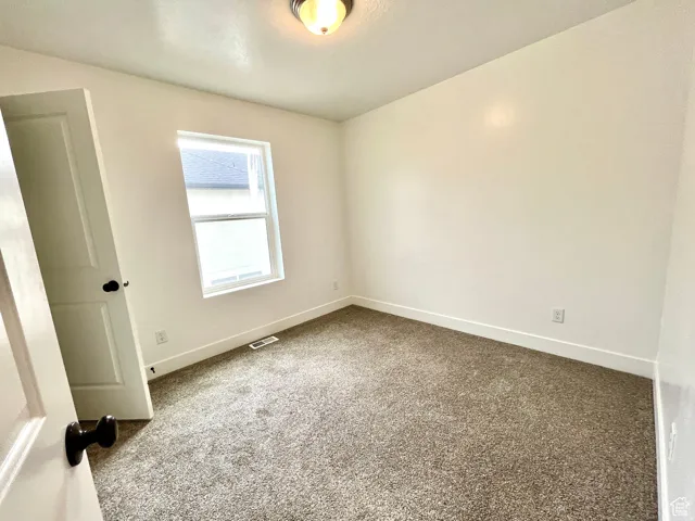 Unfurnished room with carpet and baseboards