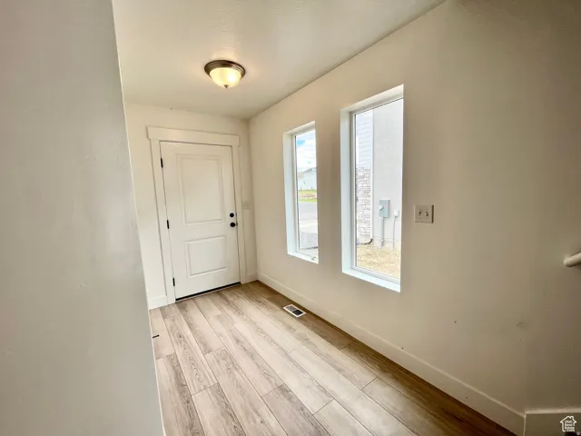 Entrance foyer featuring baseboards and light wood-type flooring