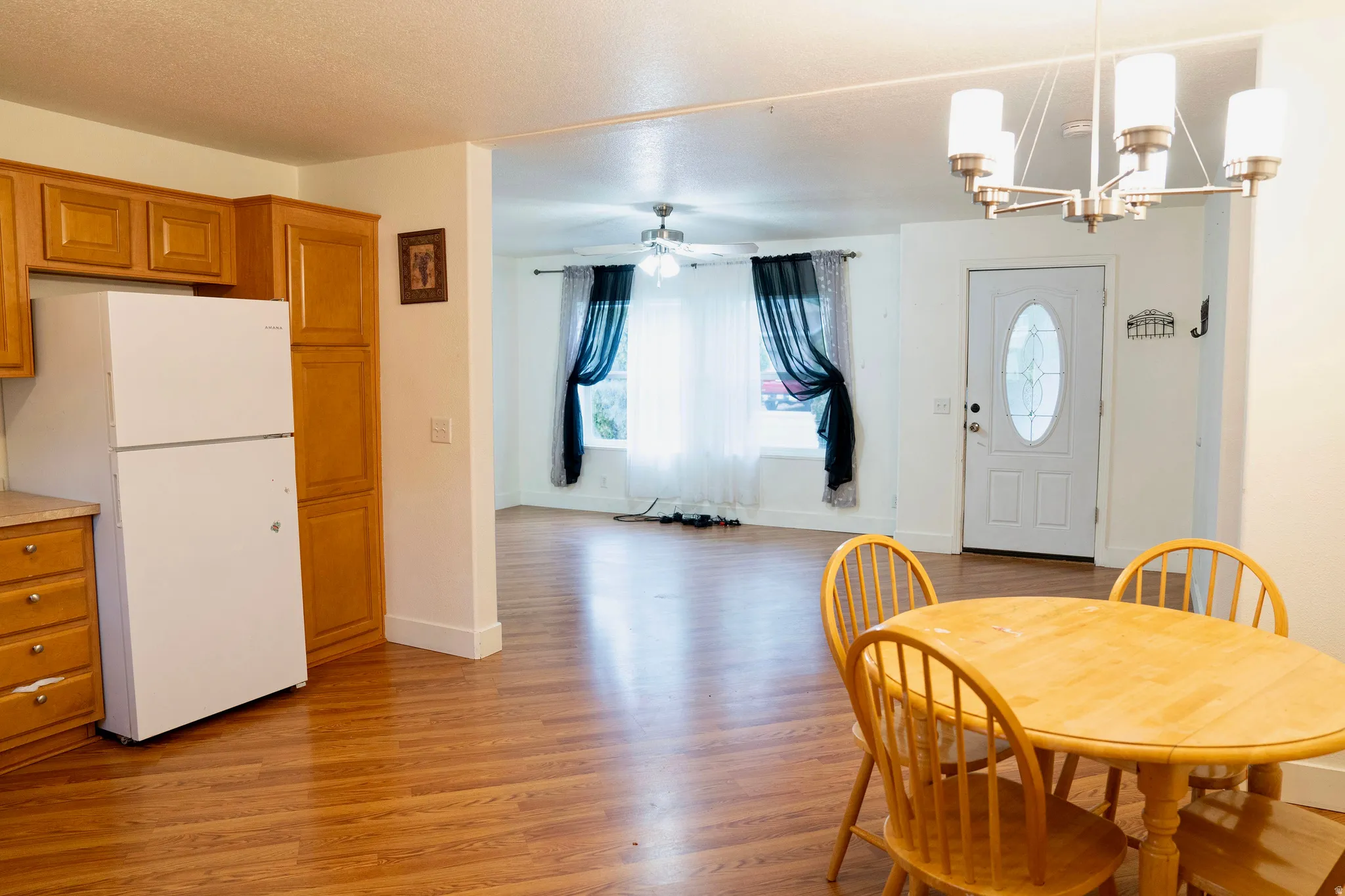 Dining space with light wood finished floors, healthy amount of natural light, and a chandelier