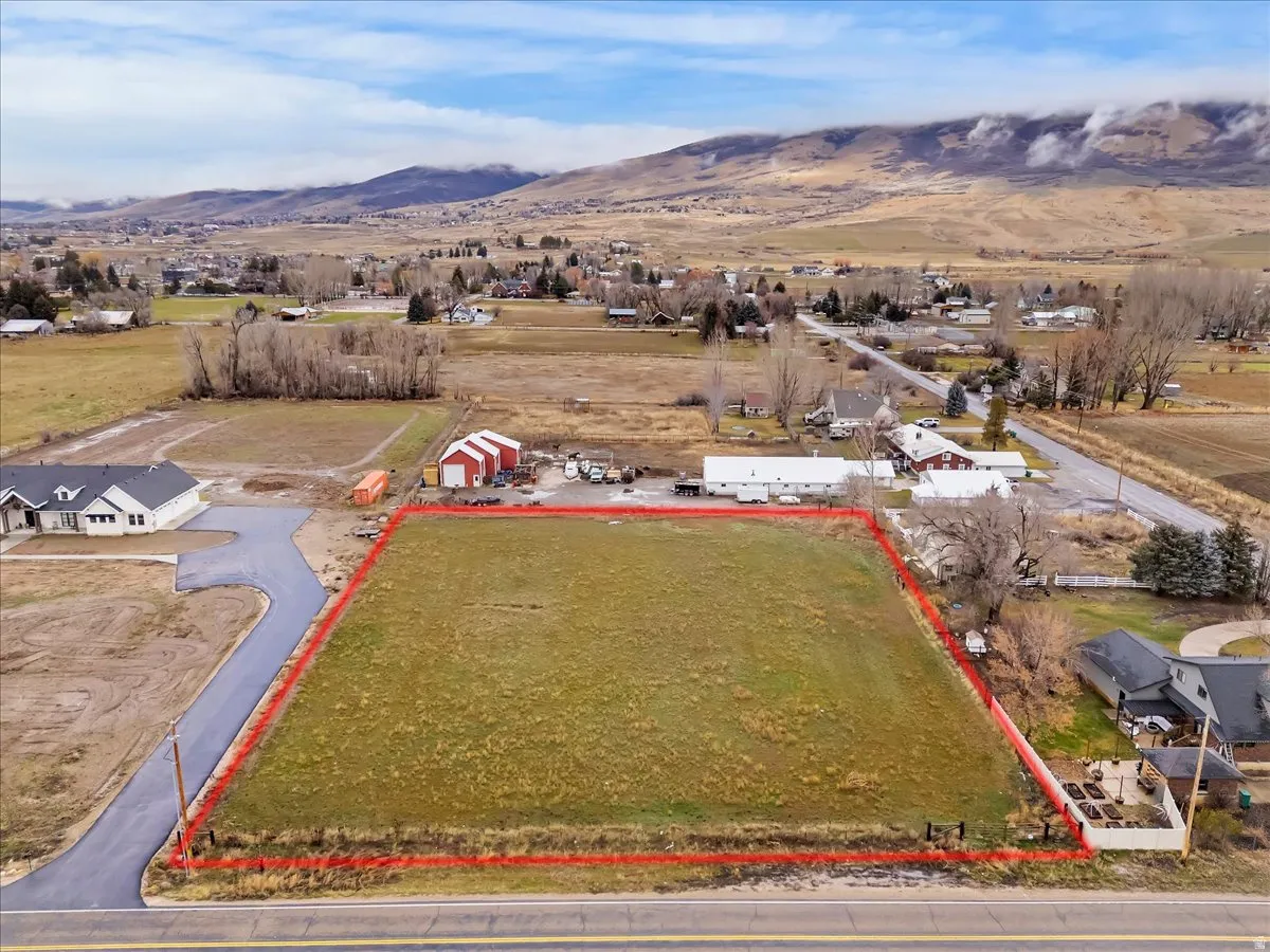 Aerial view of property's location with property boundaries highlighted and a mountainous background