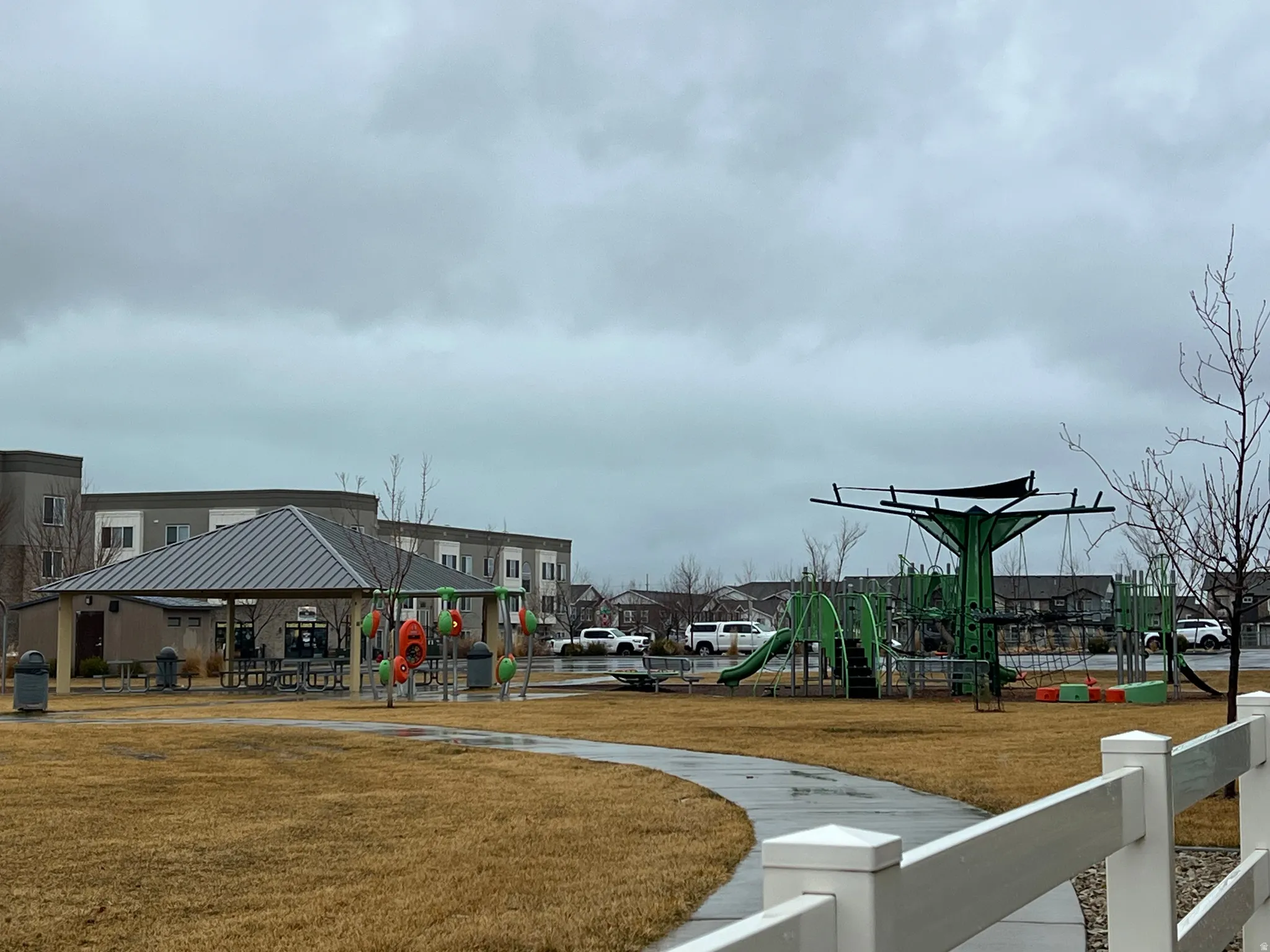 Community play area with a lawn and a residential view