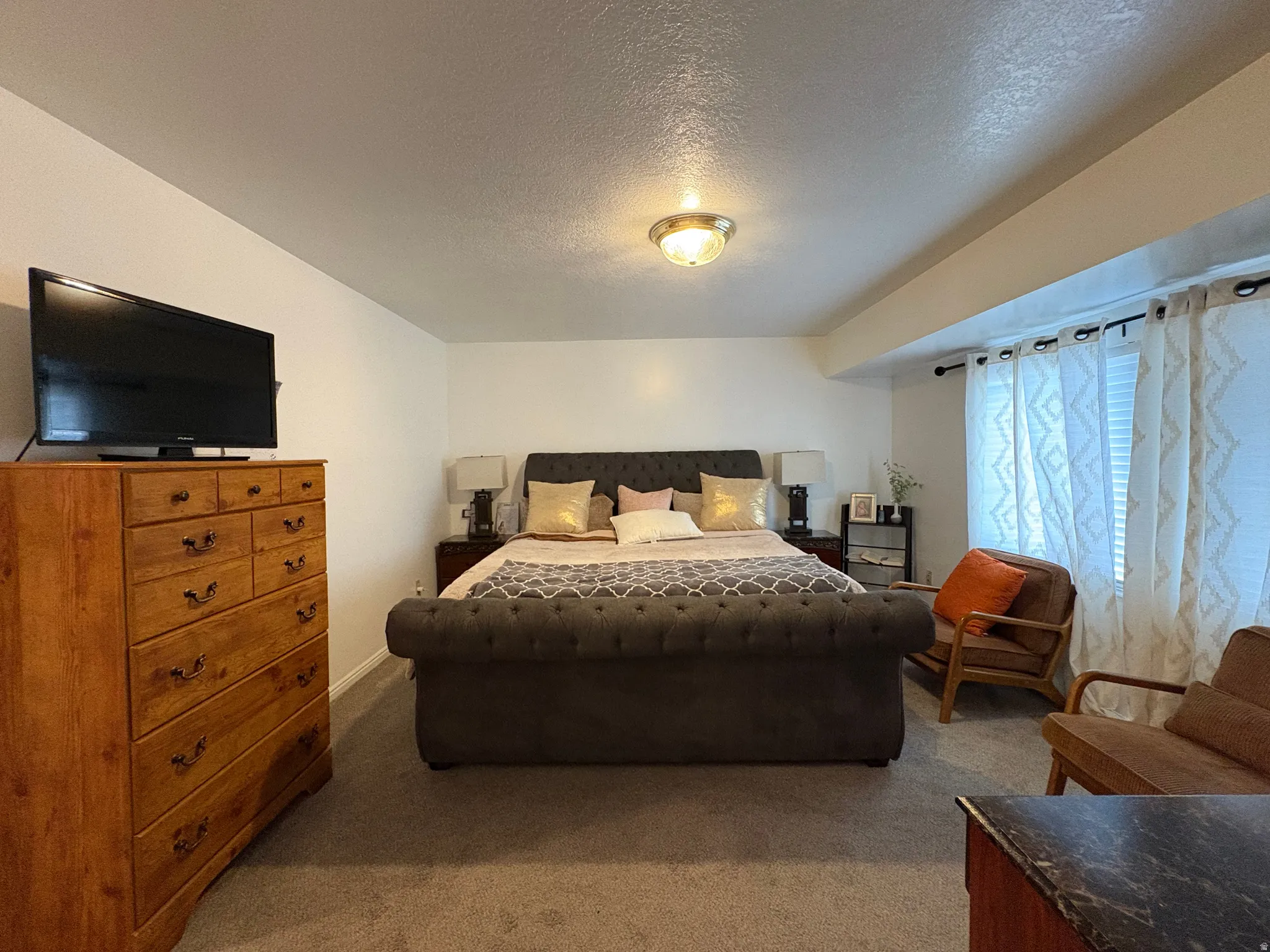 Carpeted bedroom featuring a textured ceiling