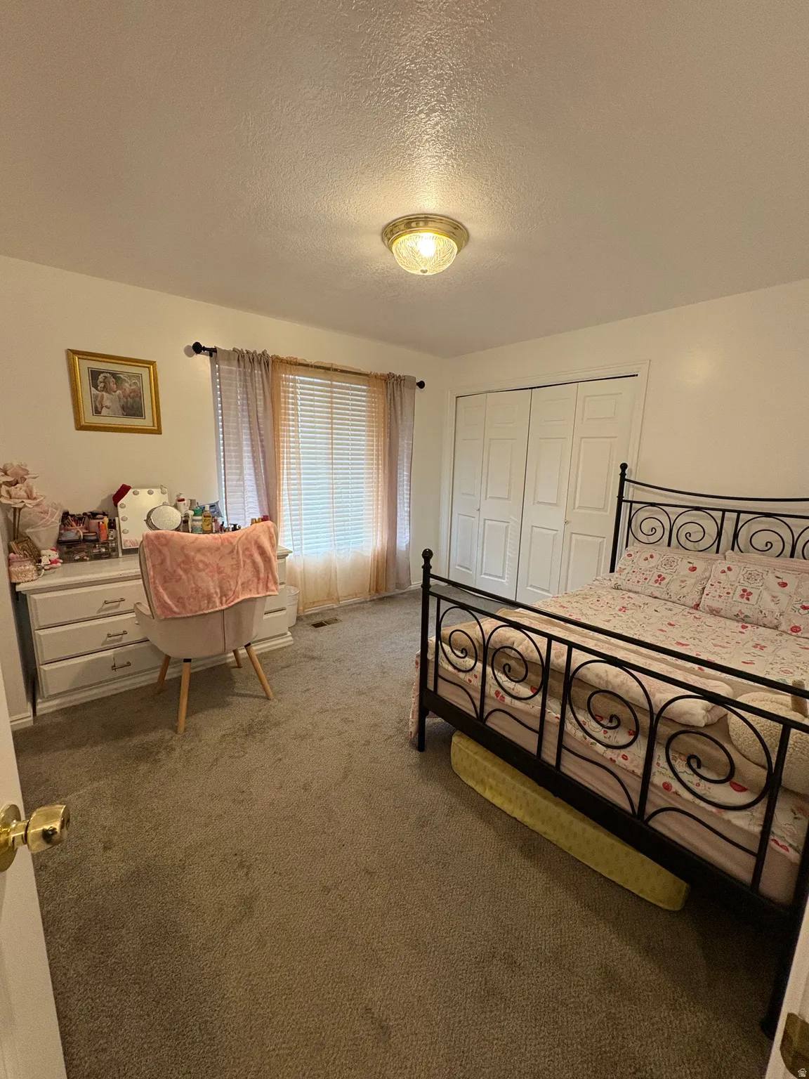 Carpeted bedroom with a closet and a textured ceiling